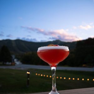 pink cocktail with mountain backdrop